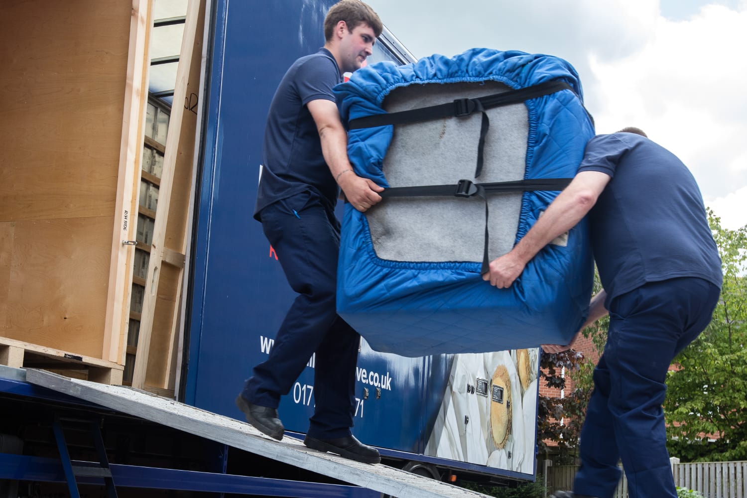 Steeles Removals employees carrying furniture out of lorry during house move