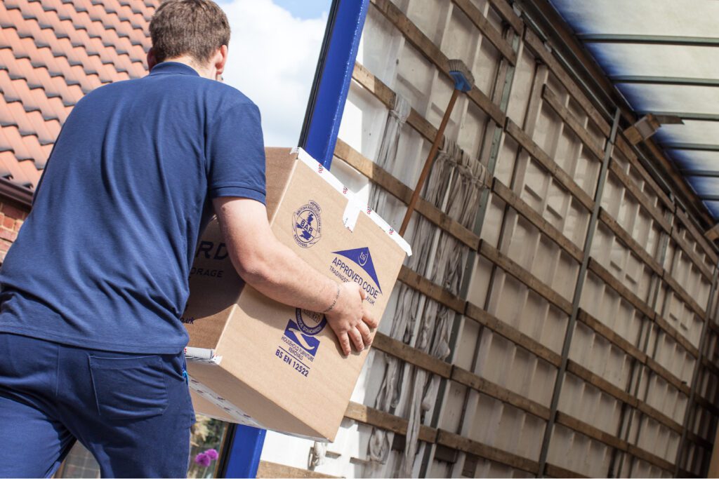 Steeles of Stamford employee loading a packing box into a removals lorry