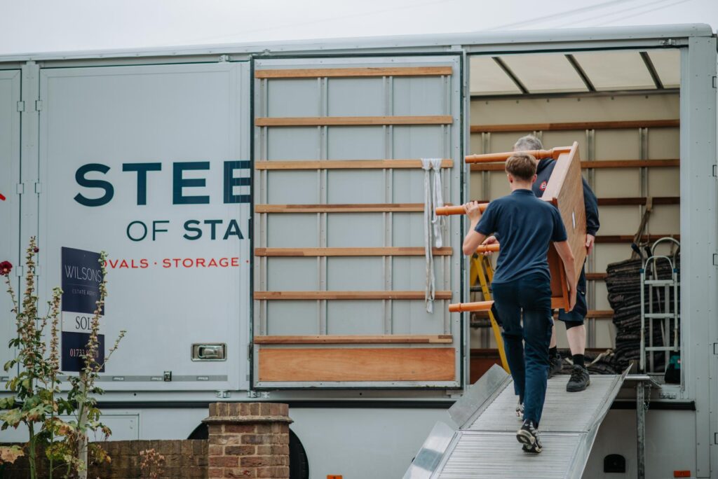 Men loading dining table into a Steeles of Stamford lorry