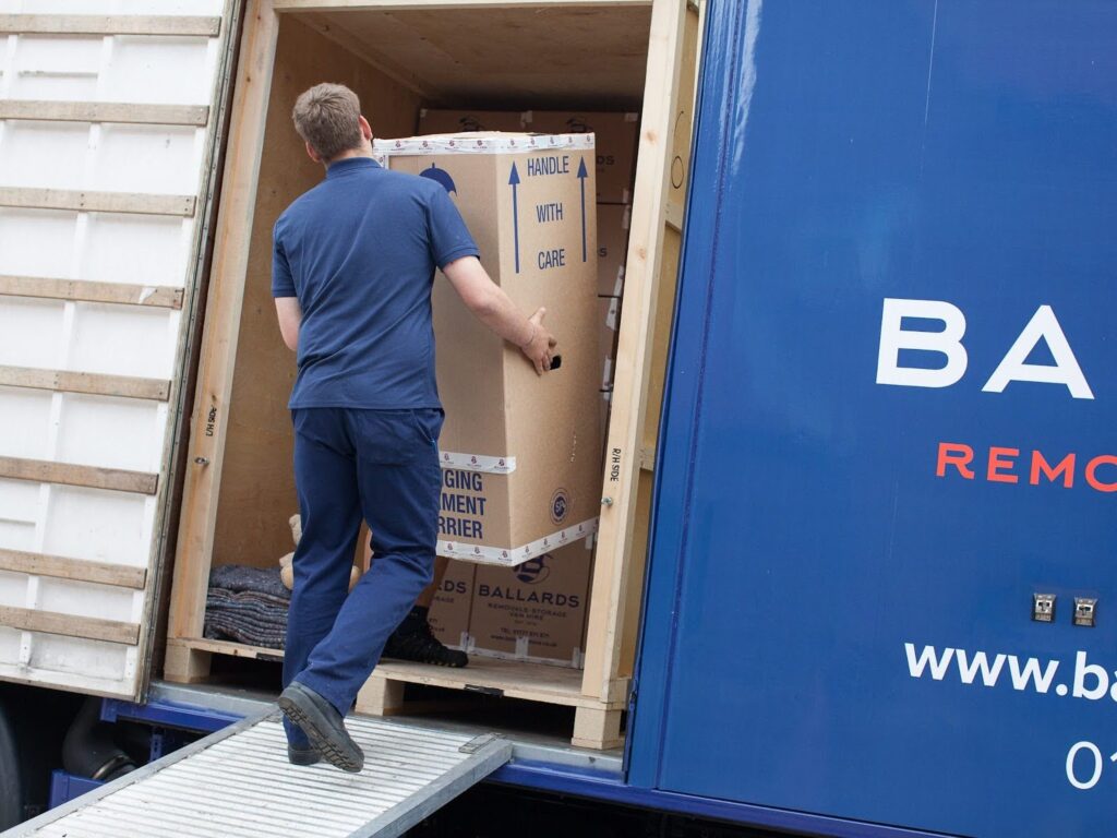 Man packing boxes from house into removals van